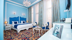 Une chambre à coucher avec un grand lit, un lustre, un bureau et une chaise.