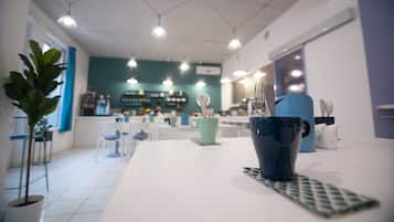 A modern interior with a white table, a blue mug, and a green cup.