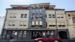 Un hôtel appelé CIVITAS, doté d’une façade en pierre, de nombreuses fenêtres et de jardinières fleuries.