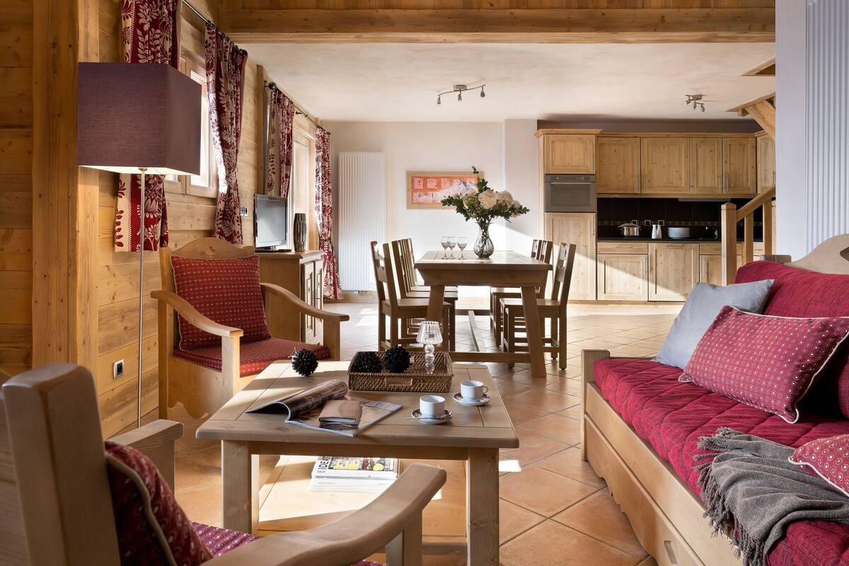Un intérieur chaleureux en bois, comprenant un coin repas, un canapé et une cuisine.
