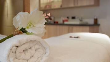 Cozy retreat with a neatly made bed, complete with a plush towel and a single flower.