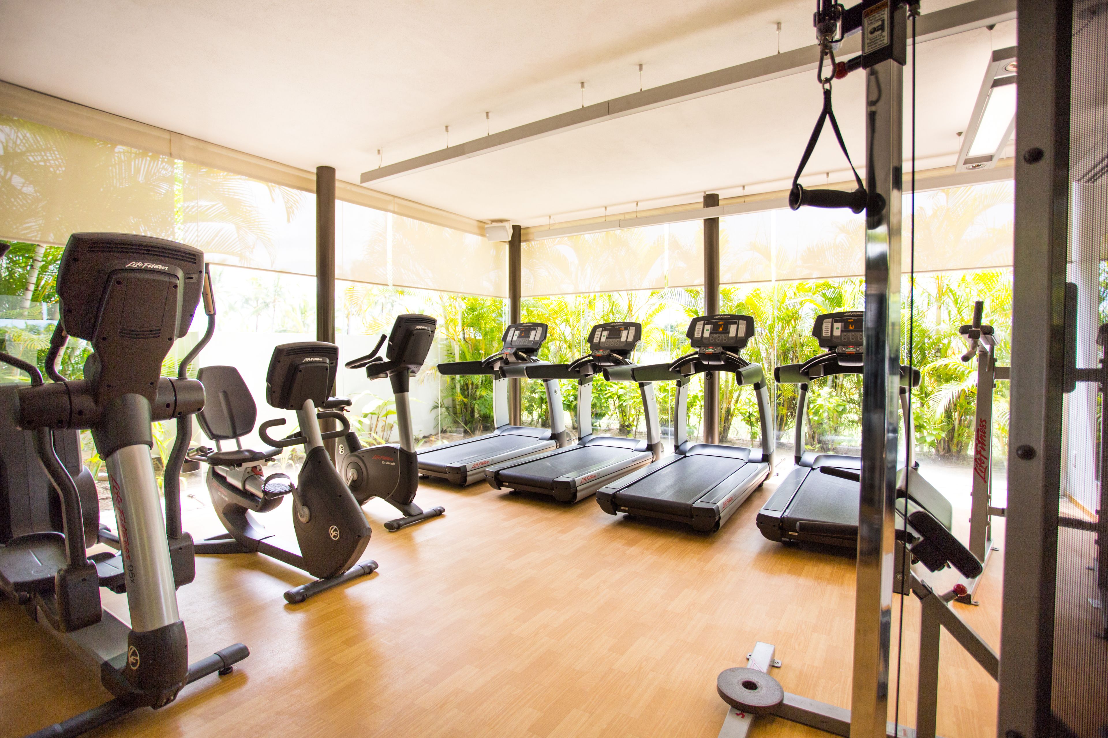A gym with treadmills, elliptical machines, and weight equipment.