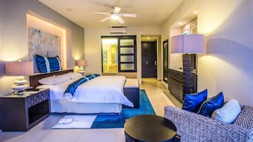 Une chambre d’hôtel moderne équipée d’un lit, d’un coin salon et d’un ventilateur de plafond.