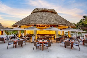 Enjoy al fresco dining under the shade of our thatched-roof structure.