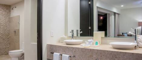 Un baño moderno con dos lavamanos, un espejo grande y una zona de ducha.