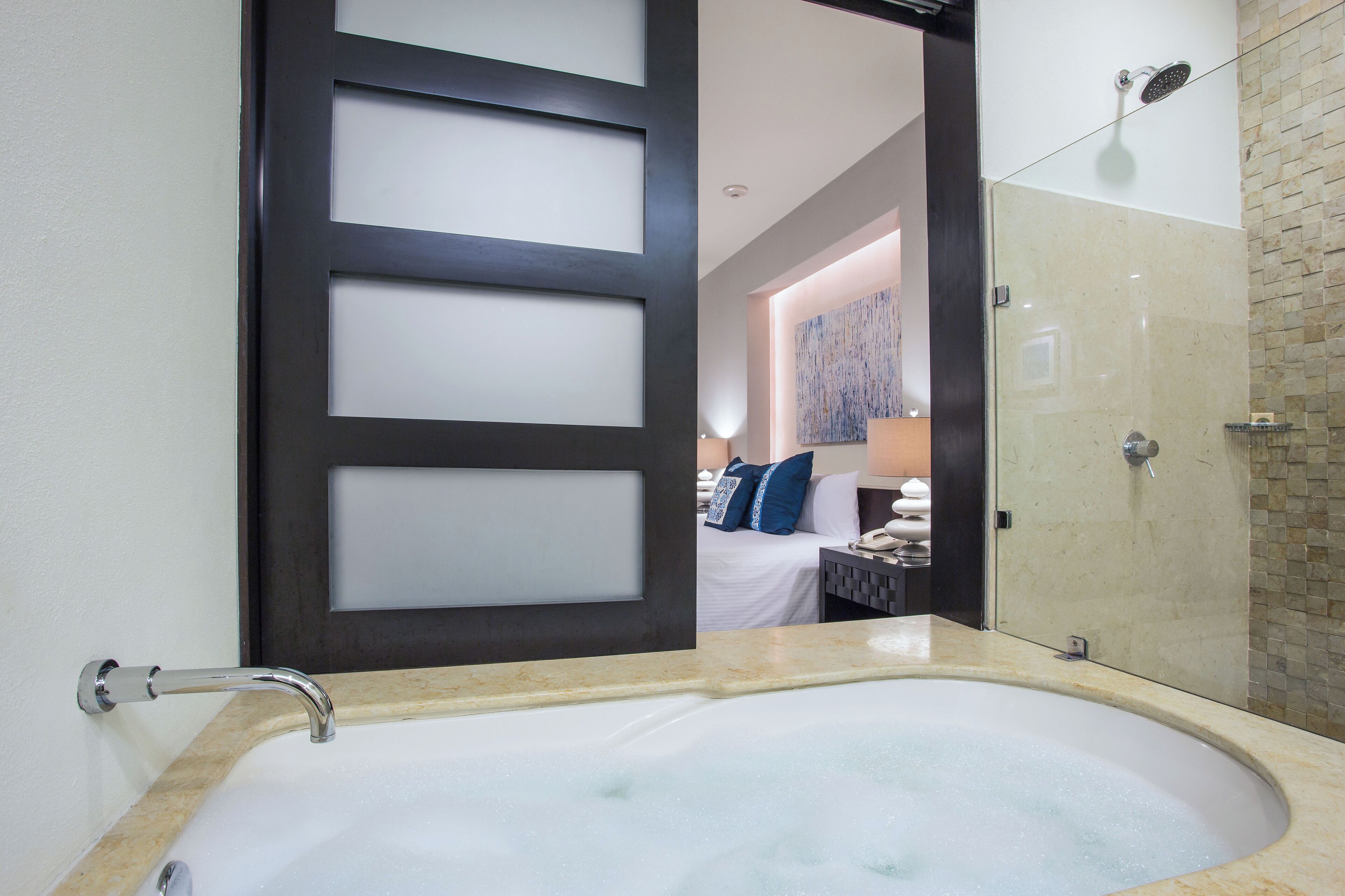 Un baño con bañera, ducha y puerta de vidrio.