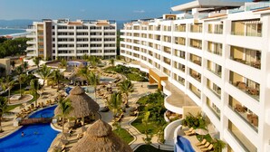 A resort with multiple swimming pools, a large slide, and thatched-roof structures. - Marival Distinct All-Inclusive Handwritten Collection (Nuevo Nayarit)