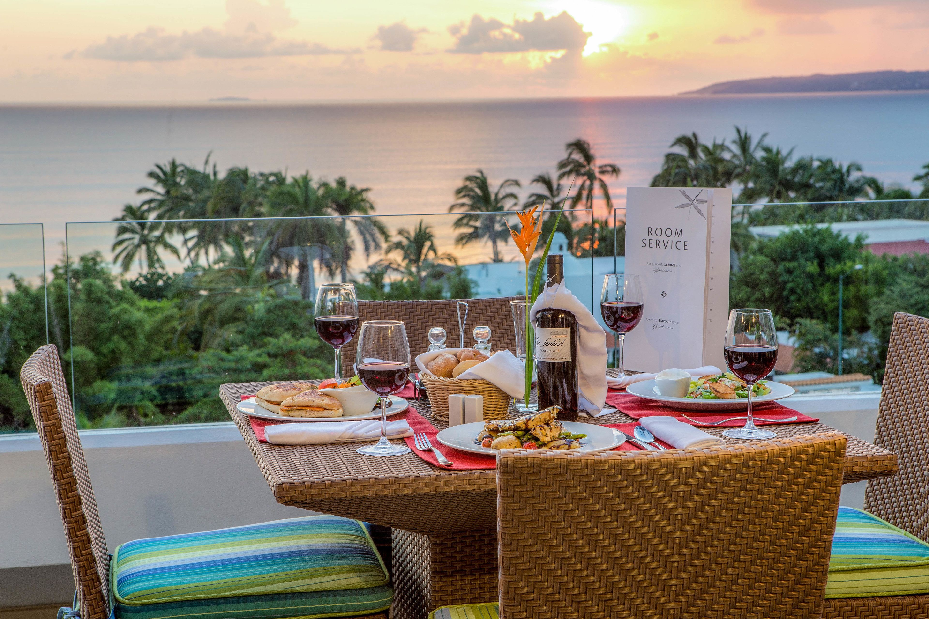 A dining table set with plates of food, glasses of wine, and a menu sign.