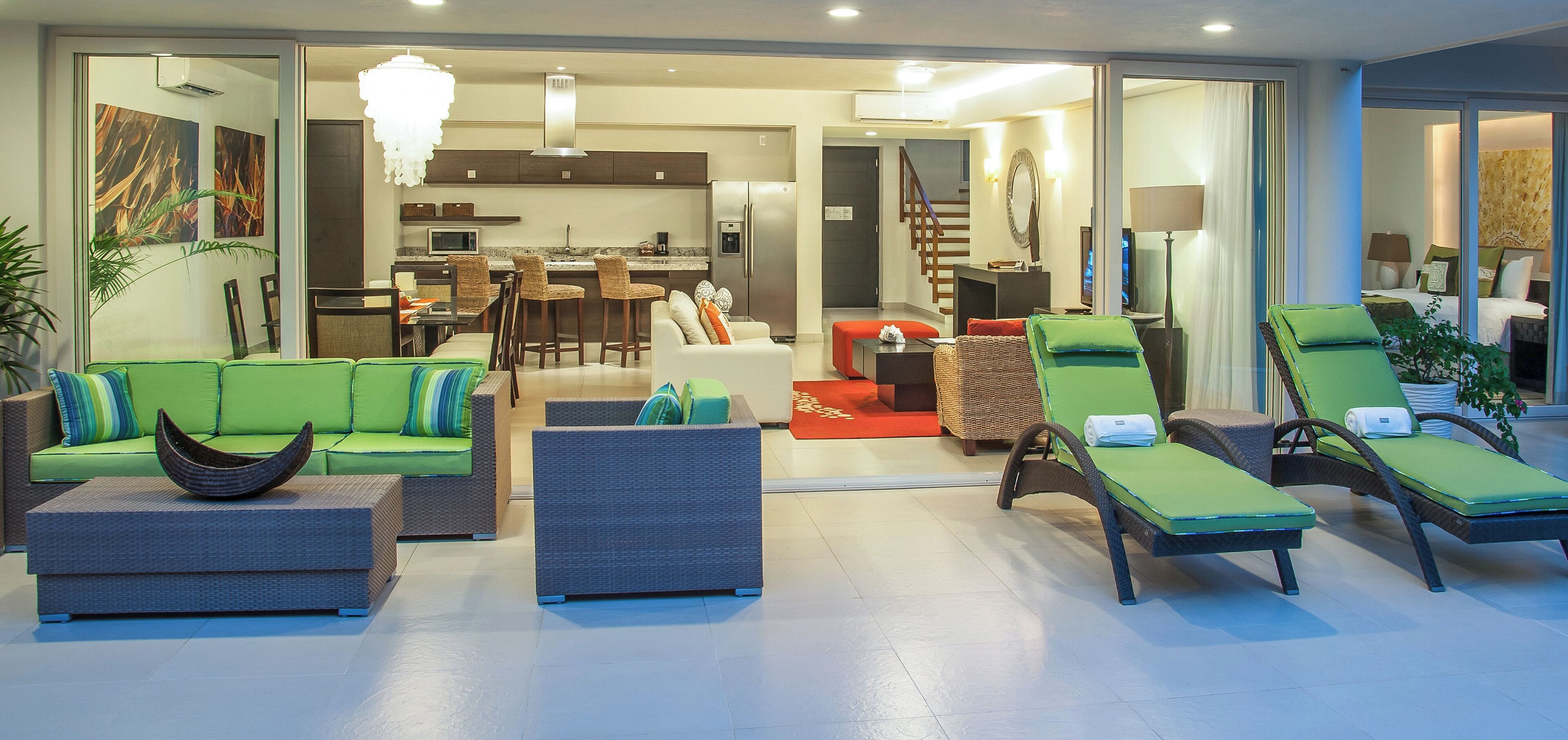 Un moderno vestíbulo de hotel con un sofá verde, sillones de descanso y un área de comedor.