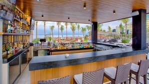 A bar with a view of palm trees and a beach. - Marival Distinct All-Inclusive Handwritten Collection (Nuevo Nayarit)