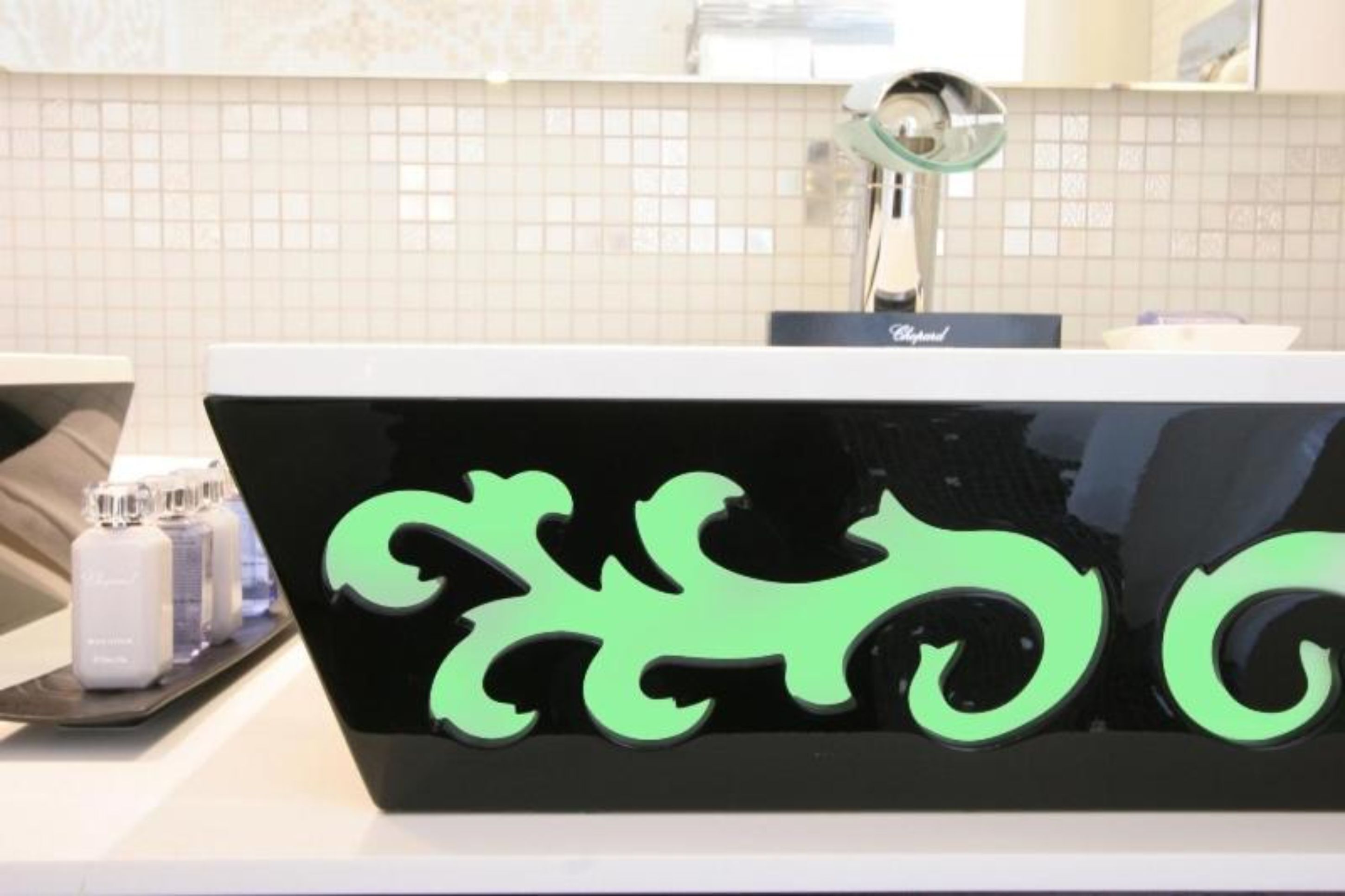Ein Badezimmer mit einem schwarzen Waschbecken und einem grünen Logo.