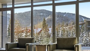 A modern interior with large windows offering a view of a snow-covered mountain landscape. - Hyatt Centric Park City (Park City)