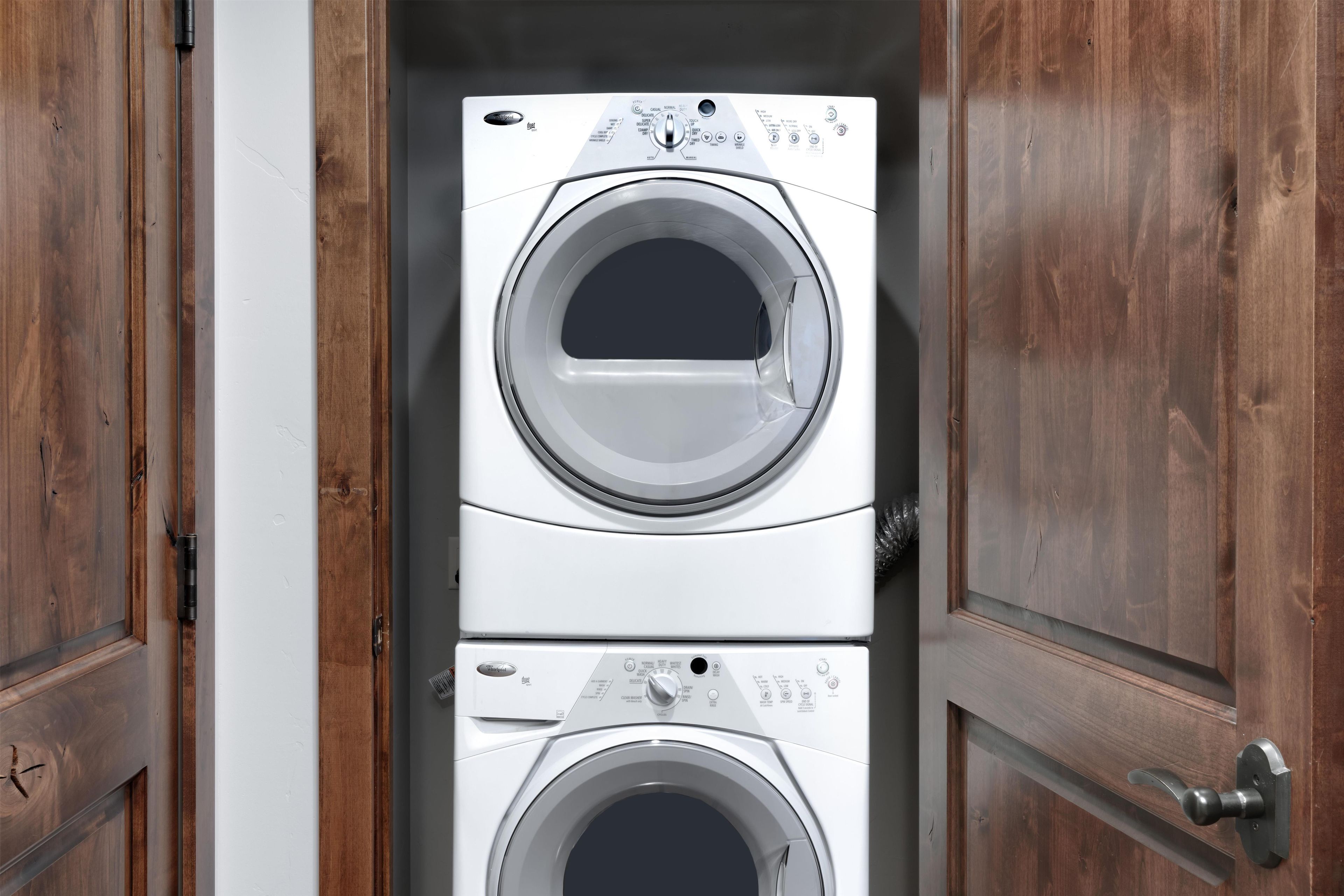 A double-door laundry room with a front-loading washer and dryer.