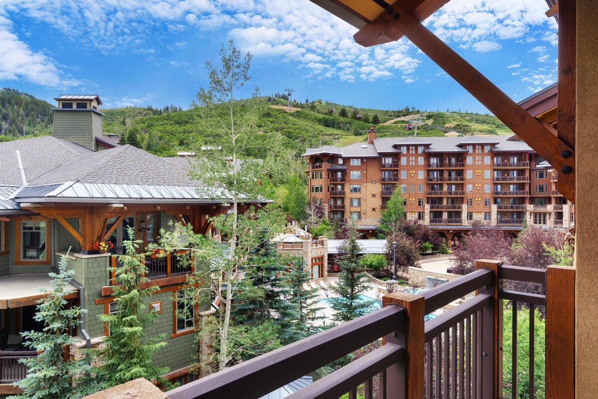 Ein Hotel mit mehreren Etagen, einem Poolbereich und Blick auf eine gebirgige Landschaft.