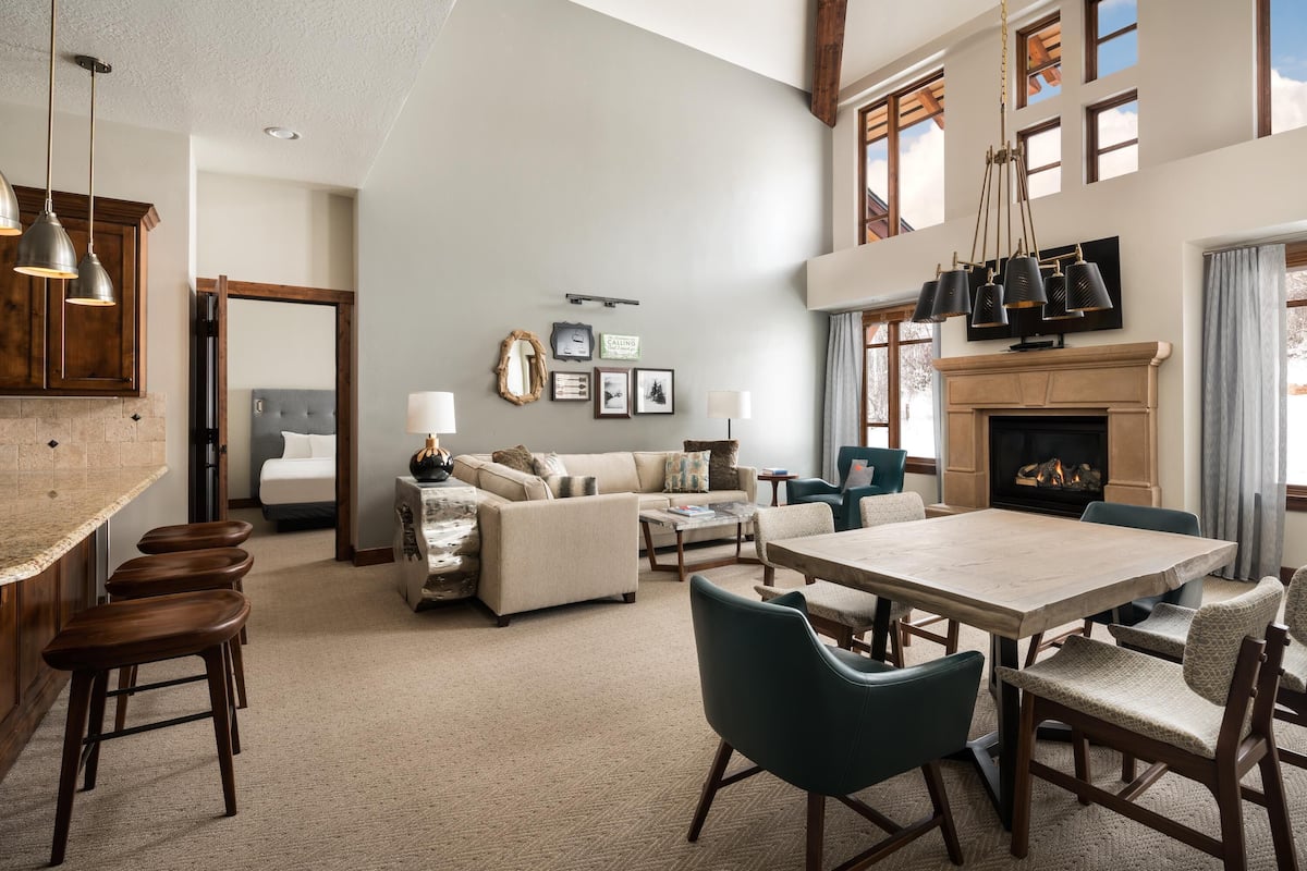 A spacious living area with a fireplace, a dining table, and a sofa.