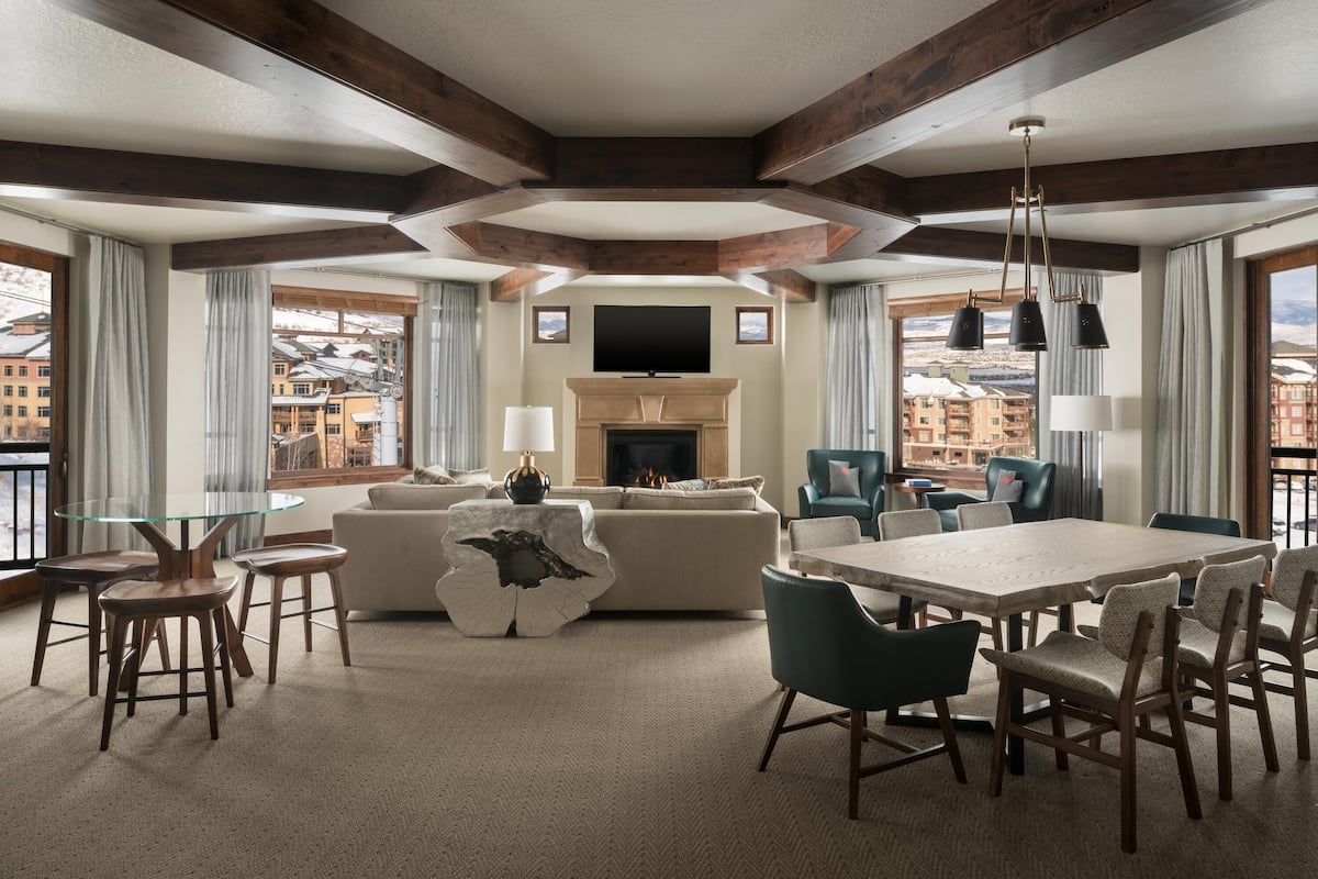 A spacious living room with a fireplace, a television, and a dining area with a table and chairs.