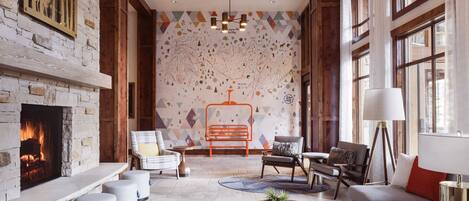 A spacious living area with a fireplace, comfortable seating, and a decorative wall mural.