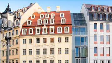 Una hilera de edificios de varios pisos con diversos estilos arquitectónicos, incluyendo fachadas tradicionales y ventanas de vidrio moderno.