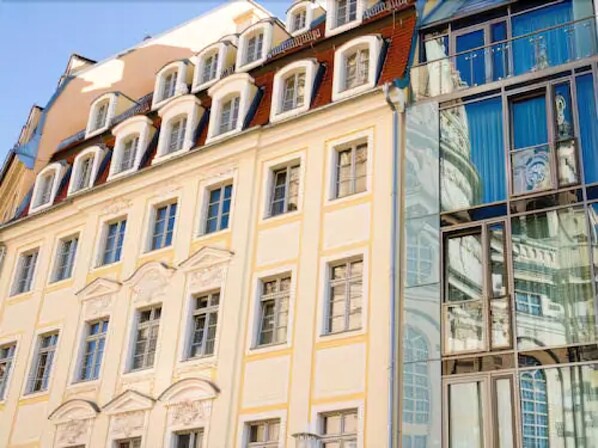 Un edificio de varios pisos con estilo arquitectónico clásico, con ventanas simétricas y molduras decorativas.