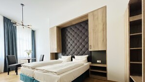 A modern hotel room with a large bed, built-in wardrobe, and a dining area. - Aparthotel Altes Dresden (Dresden)