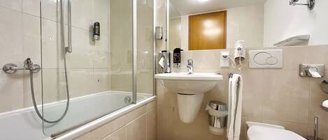 A modern bathroom with a glass-enclosed shower, a standalone sink, and a toilet.
