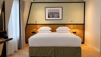 Habitación de hotel con una cama grande, dos mesitas de noche con lámparas, un cuadro en la pared y una ventana con cortinas.