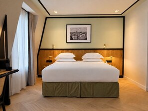 A hotel room with a large bed, two bedside tables with lamps, a framed picture on the wall, and a window with curtains. - Hotel Maison Lenoir (Paris)