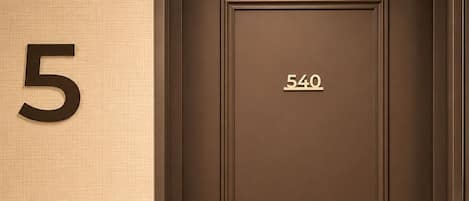A hotel room door with the number 540 and a large number 5 on the wall.
