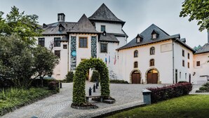 A historic building with a courtyard, stone pathway, and a central archway.