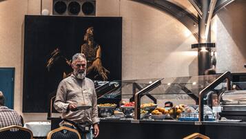 Un'area buffet con diversi cibi e una persona che vi si trova di fronte.