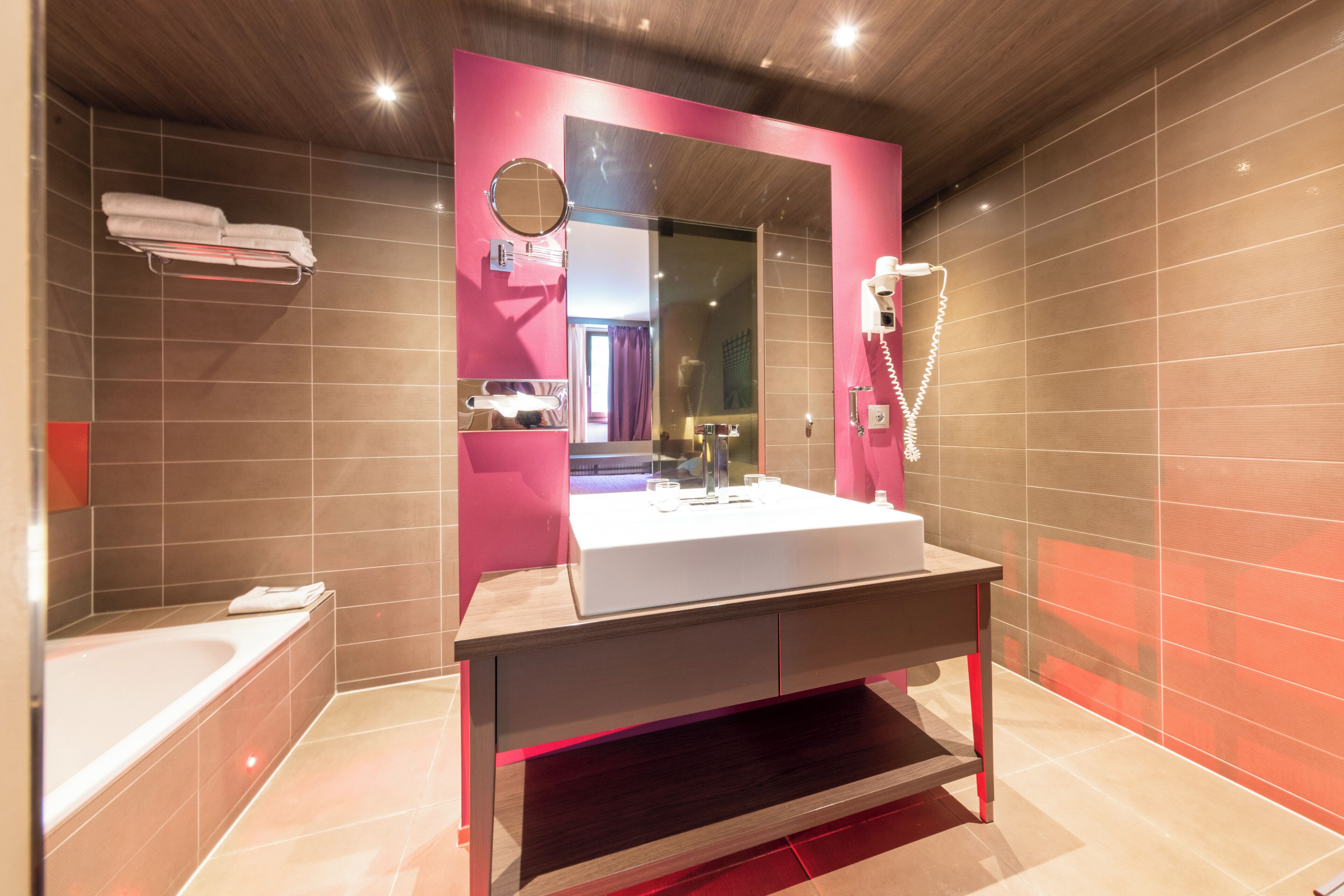 Ein modernes Badezimmer mit großem Spiegel, Waschbecken, Dusche und Badewanne.