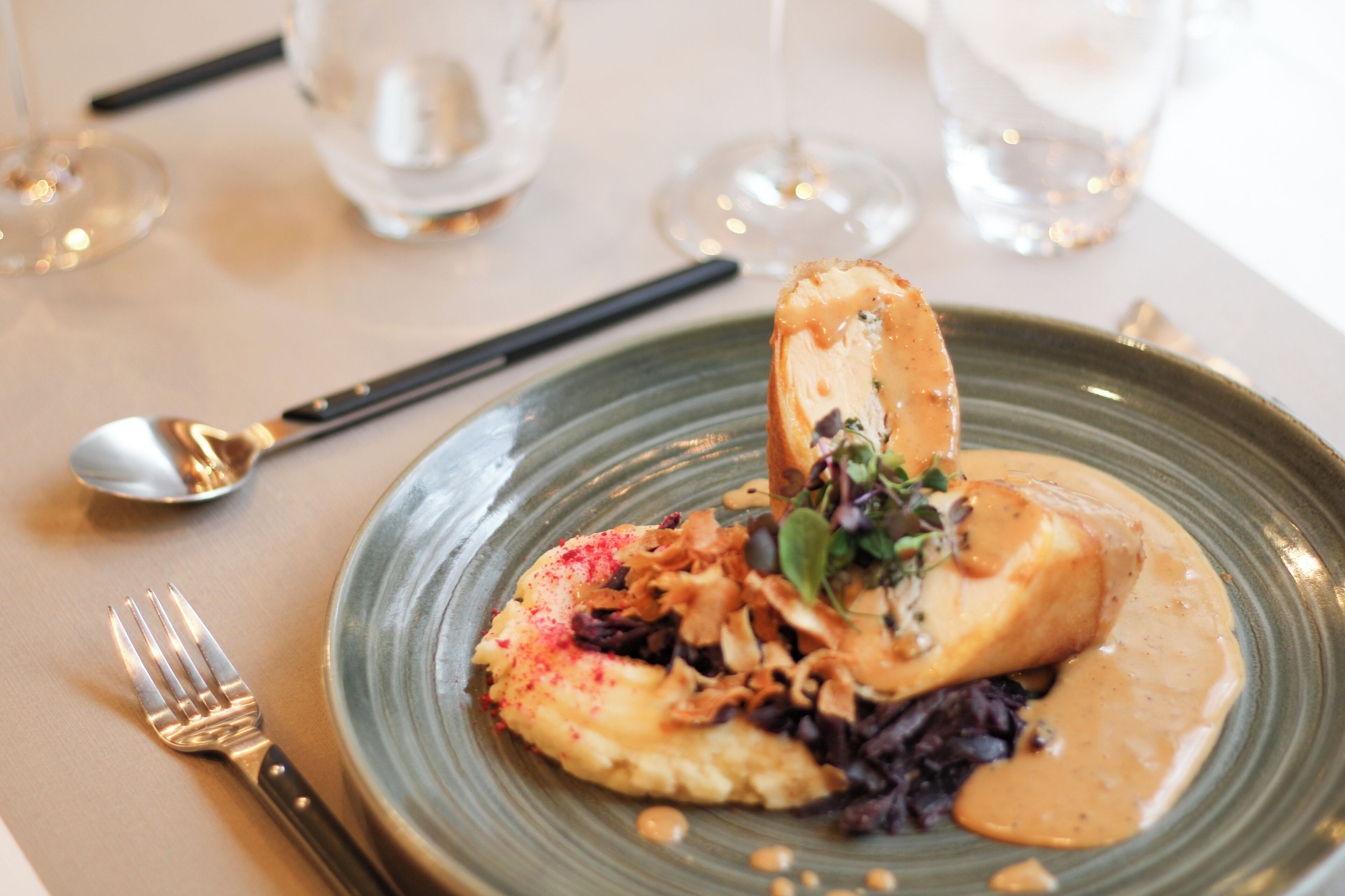 A plate of food with a fork and spoon on a table.
