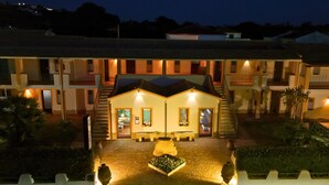Un hotel con patio central, varios balcones y tejado de tejas.