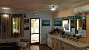 Una cocina con armarios de madera, un lavamanos y una ventana con cortinas.
