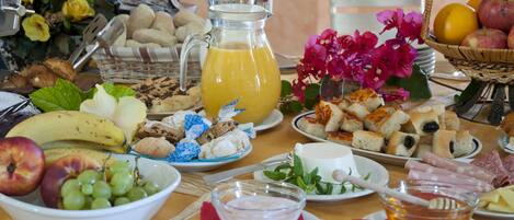 A breakfast buffet with various food items and a pitcher of orange juice.