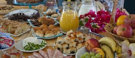 A breakfast buffet with various food items and a pitcher of orange juice.