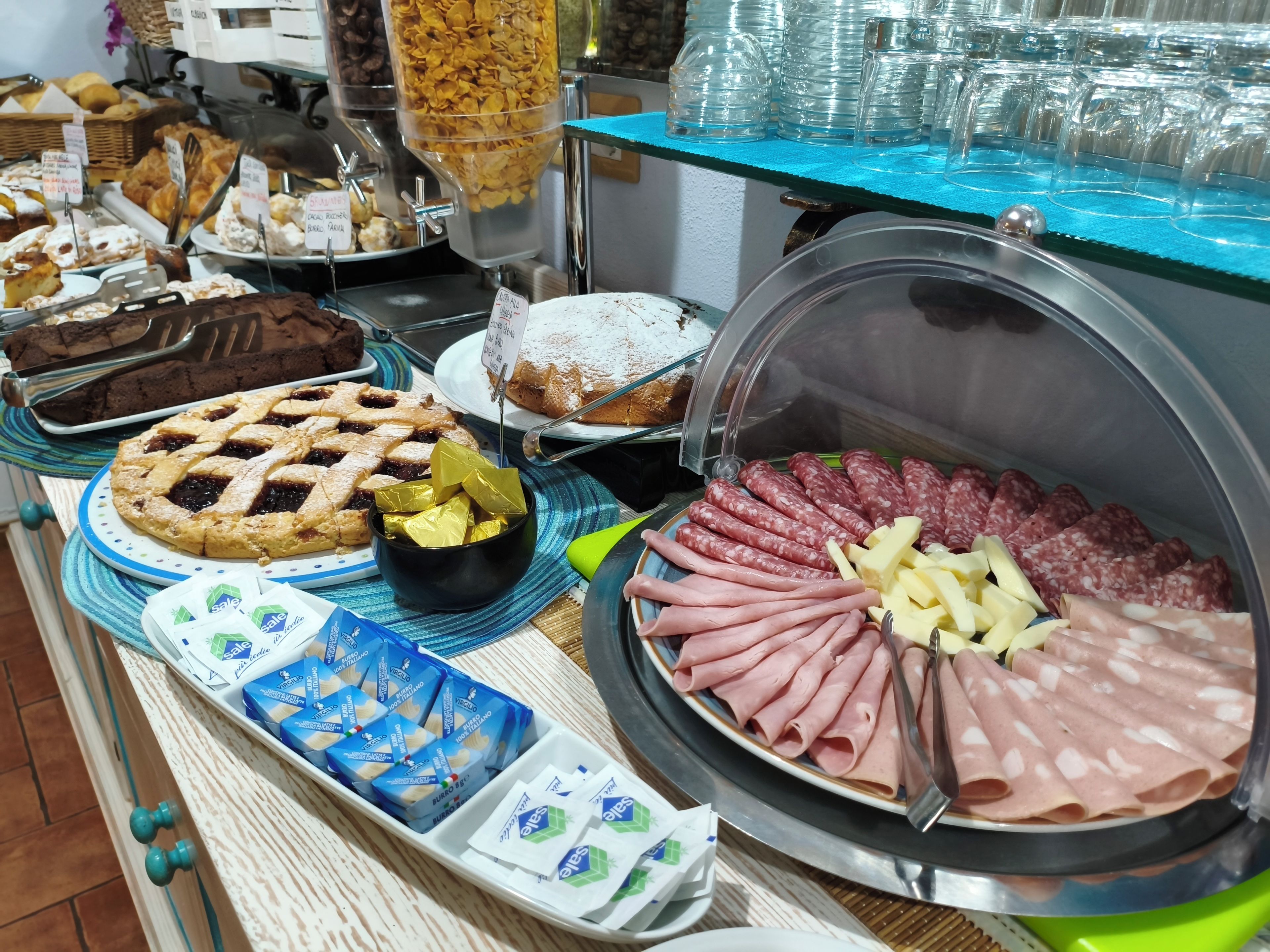 Un buffet con diversi cibi, tra cui pasticcini, una torta e una selezione di carni.