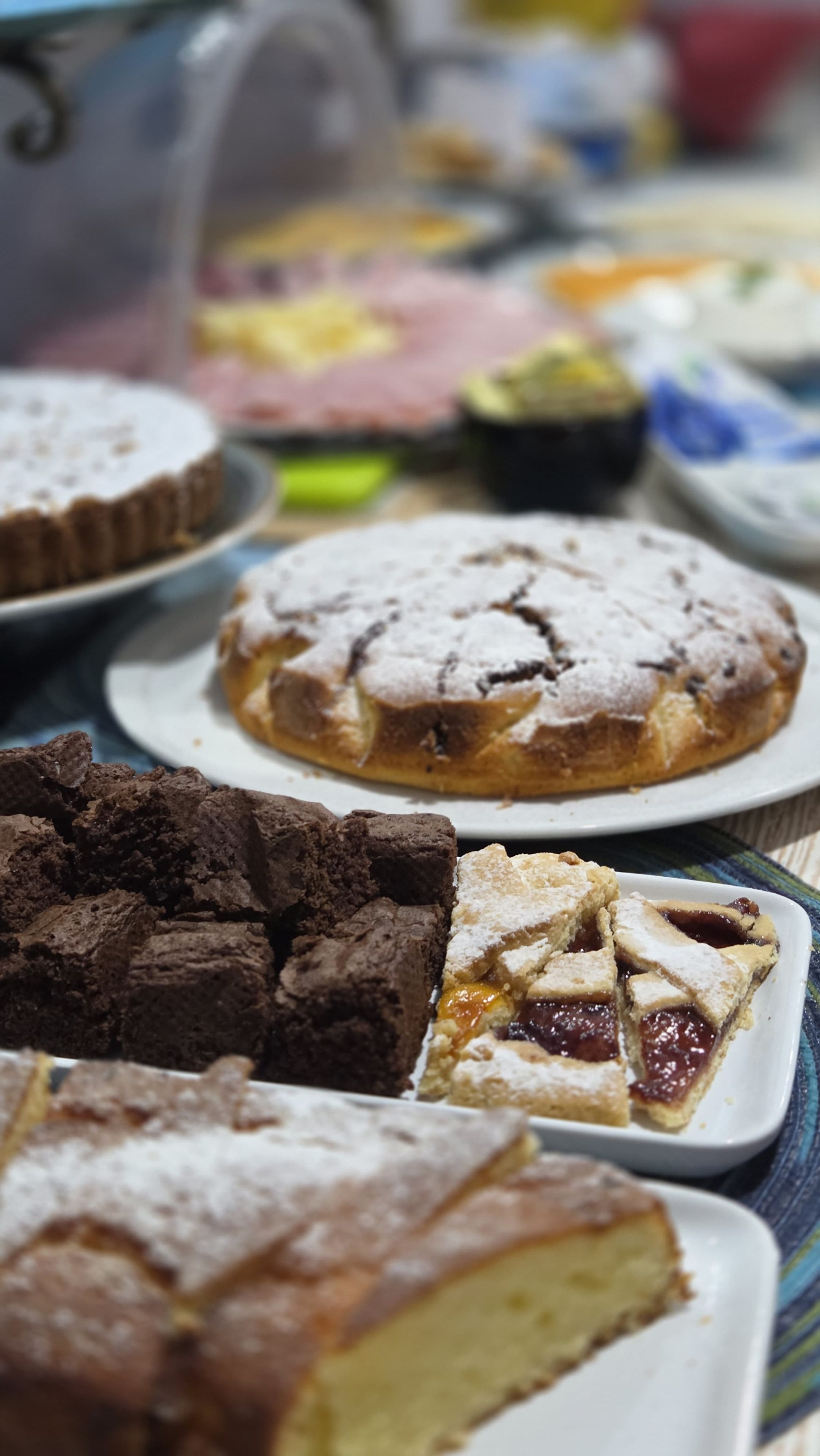 Verschiedene Desserts auf Tellern, darunter ein Kuchen mit einer Zuckerstaubschicht.