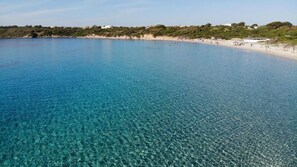 Una playa cerca, arena blanca, sillas reclinables de playa, sombrillas