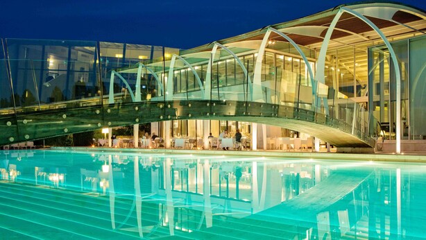 A modern building with a glass bridge over a pool. - Riviera Golf Resort (San Giovanni In Marignano)