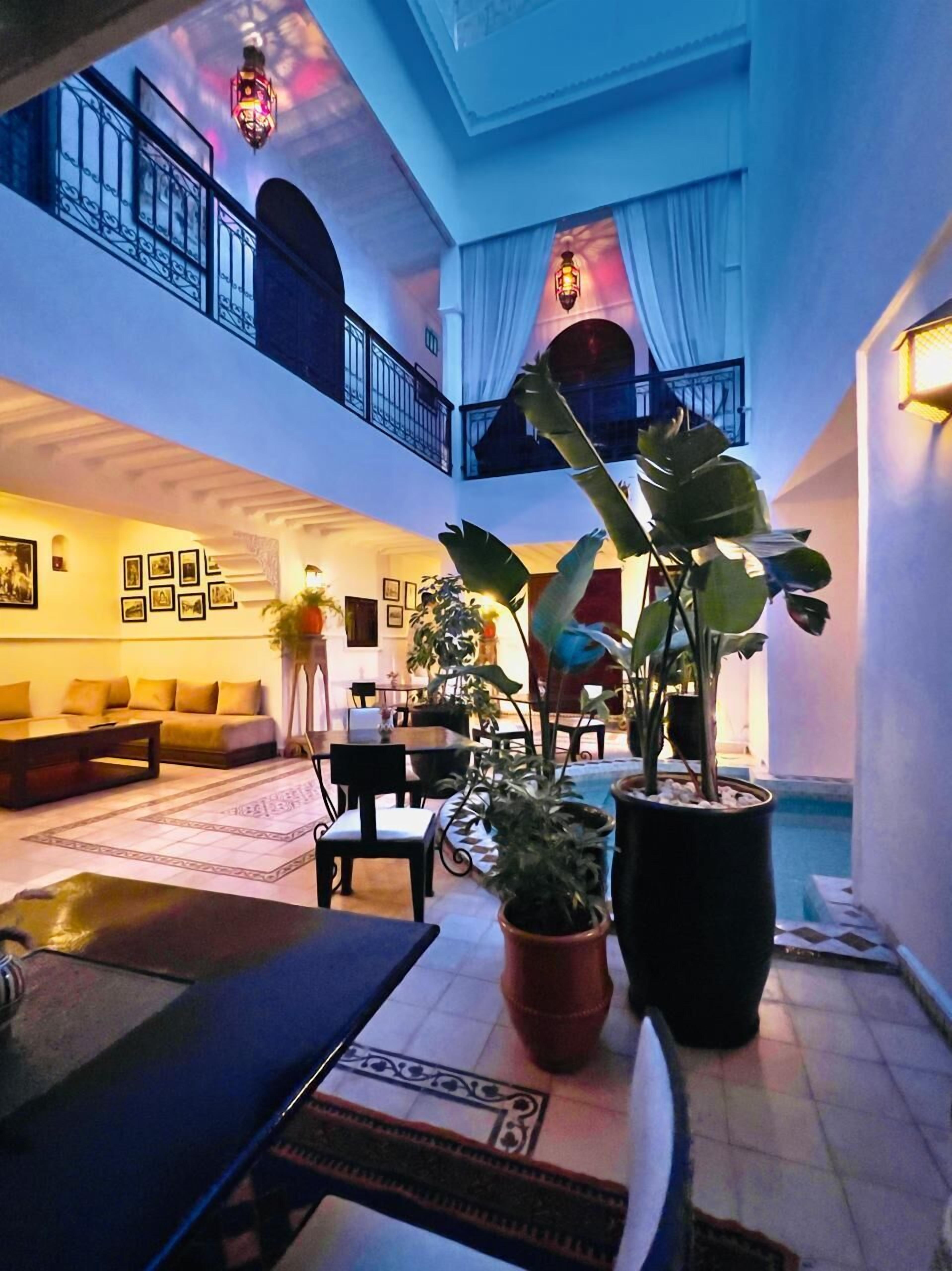 A spacious living area with a high ceiling, a balcony, and a pool area.