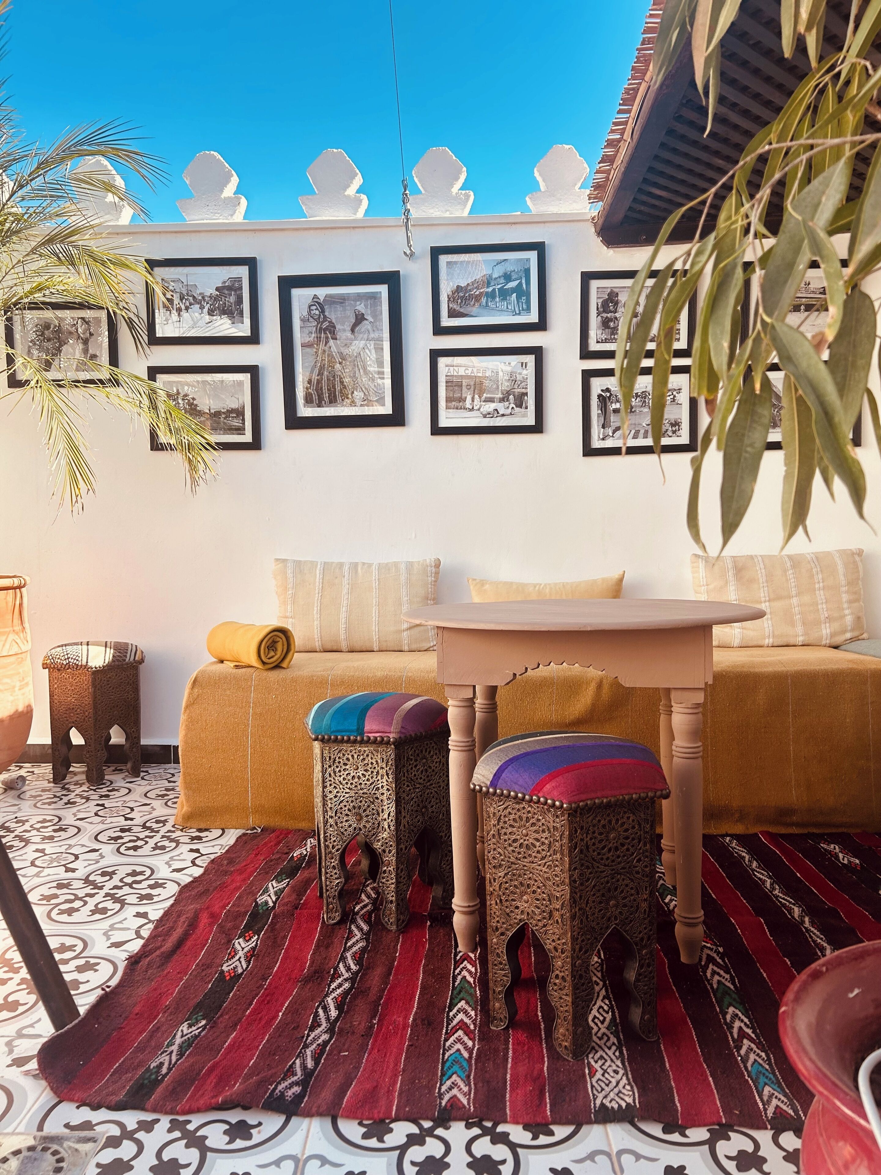 A cozy seating area with a sofa, ottomans, and a table.