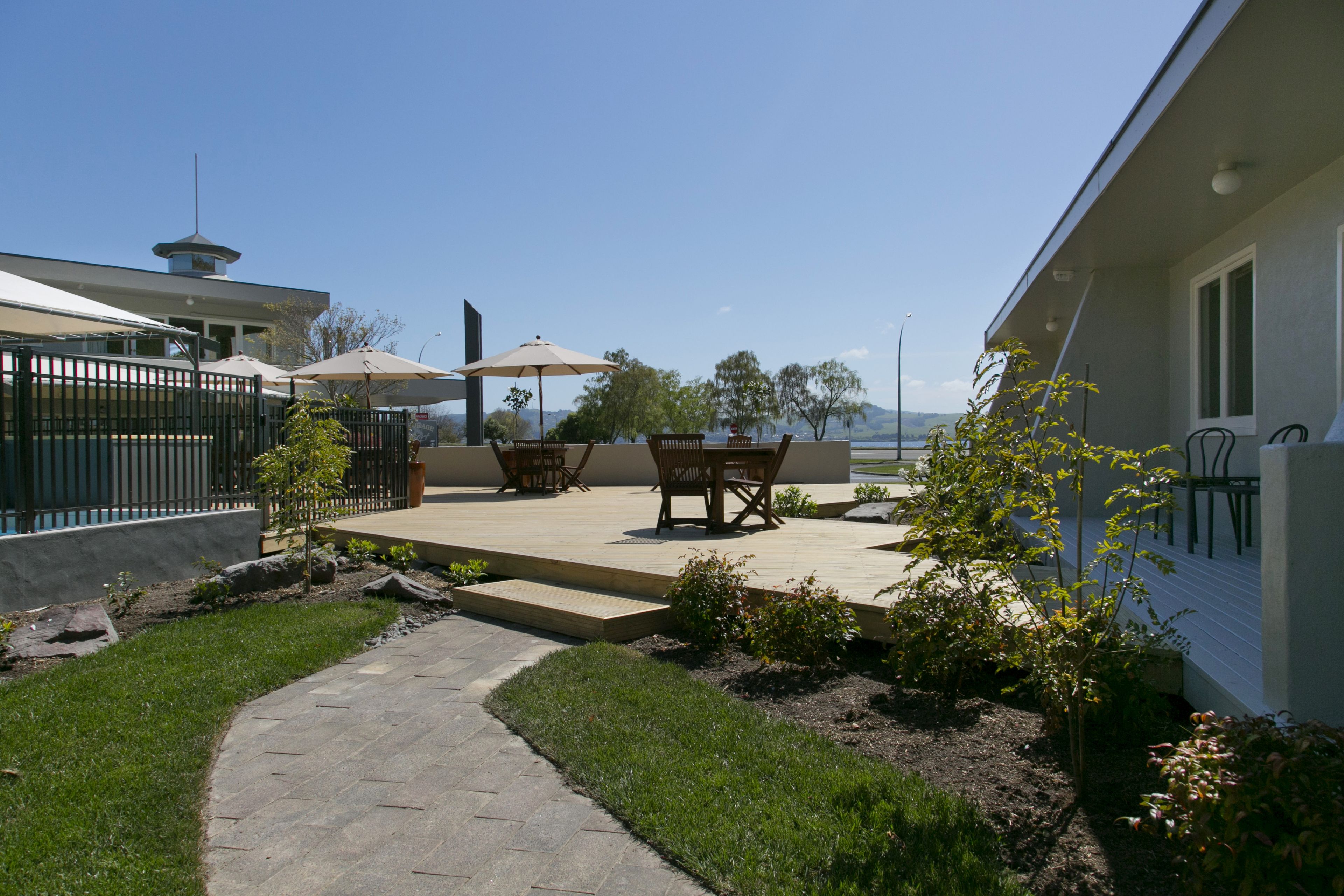 A patio area with a table and chairs, a pathway, and a view of the water.