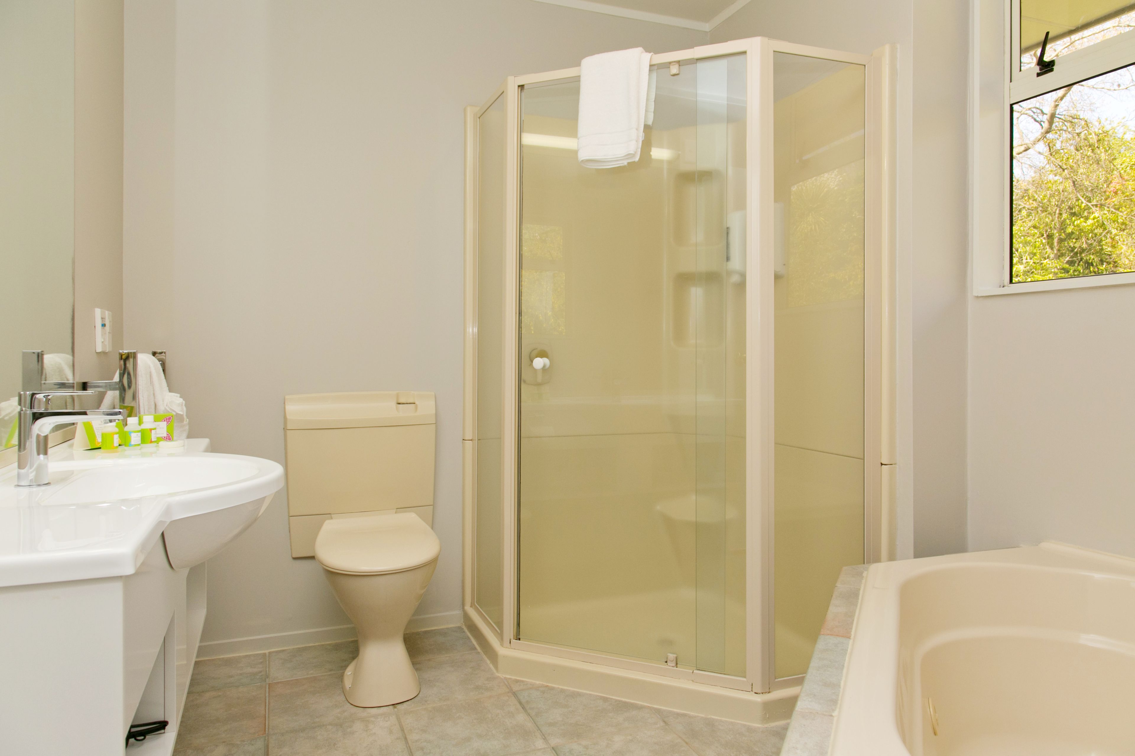 Een badkamer met toilet, wastafel, douche en bad.