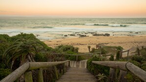 A wooden staircase leading to a beach with ocean views. - Super Tubes Guesthouse (Jeffreys Bay)
