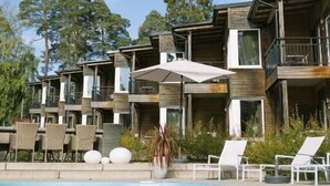 A modern hotel with multiple balconies, a swimming pool, and outdoor seating. - Engeltofta Sea Lodge Hotel (Gävle)