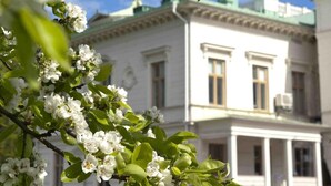 A building with a classical architectural style, featuring a symmetrical facade, columns, and a central entrance with a porch. - Engeltofta Sea Lodge Hotel (Gävle)