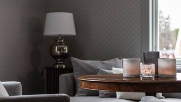 A modern living room with a grey sofa, a wooden coffee table, and a lamp.