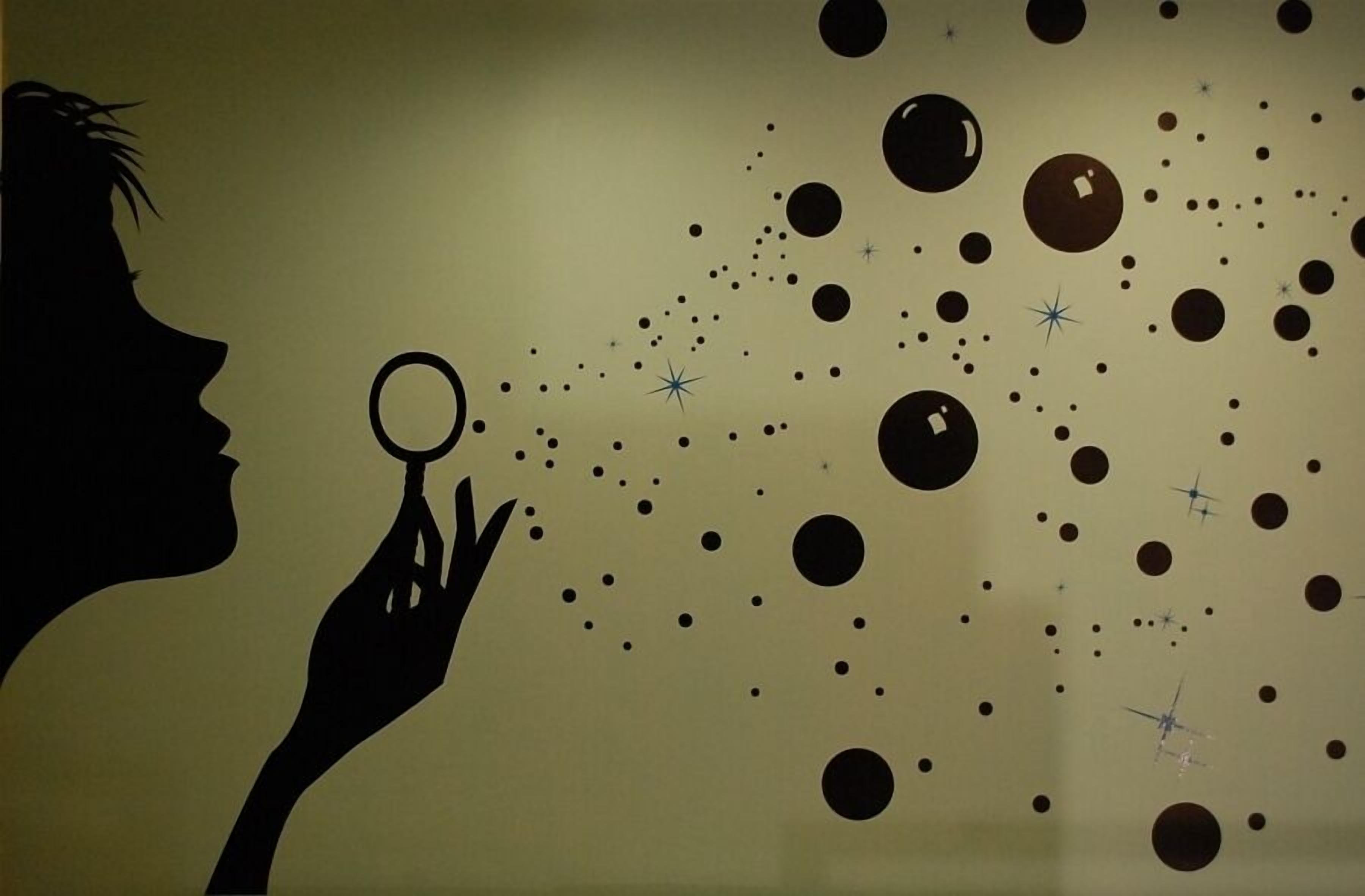 Silueta de una persona sosteniendo una lupa frente a una pared con un diseño de círculos y estrellas.