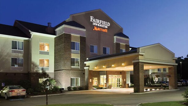 Un hotel Fairfield Inn & Suites by Marriott con fachada de ladrillo y entrada cubierta.